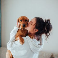 Pet parent kissing her dog
