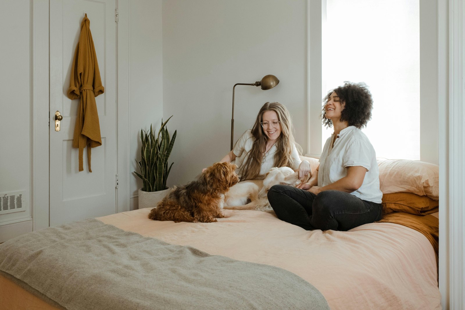 Two people relaxing on their bed with their dog, at home together